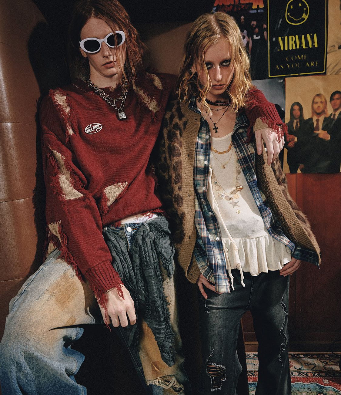 Two friends wearing grunge layers in a poster-lined rehearsal room